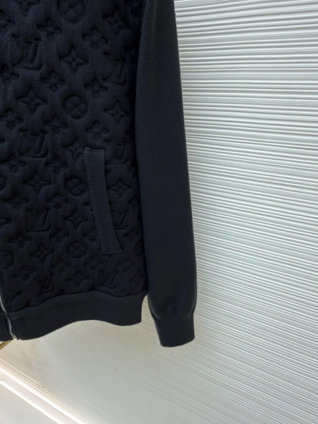 LOUIS VUITTON padded wool bomber jacket ●Original version: 25100 purchase and development ●Item number: 1681567-C10 ●Fabric: wool interwoven three-dimensional jacquard fabric ●Technology: embossed production ●Color: black ●Version: fitted version ●Weight: about 1340 grams ●Size: S-M-L-XL ●Description: Custom-woven wool interwoven three-dimensional jacquard fabric, soft as clouds, thick and solid Every inch of fiber contains a heavy warmth. The classic black tone exudes an innate sense of luxury. Full-width Monogram quilting is used to reconstruct the texture of the body. Each diamond grid reshapes the flat totem on the canvas into a relief building of the body. Textures of different shades are raised like reliefs. The neat frame supported by the texture. Quilted padding reconstructs the temperature philosophy of the bomber jacket. Let the iconic symbol become a walking art, molding three-dimensional Monogram embossing process Permanently shape the relief outline. Prioritize the customization of metal molds and precision lamination technology to permanently shape the Monogram pattern with an embossed three-dimensional texture. Form a three-dimensional texture with both visual concave and convex feeling and tactile relief feeling, using a laser projection positioning system. The split mold modules are accurately aligned on the fabric according to the Monogram arrangement rules to ensure that the full-width pattern is continuous and without misalignment. Multi-layer composite lining uses precise composite adhesive lining + elastic sponge + isolation film. Three layers of functional materials form the structural support of the fabric, lining and lining. To ensure that the Monogram pattern can be three-dimensionally raised and permanently shaped during molding, the shape is fixed, and the washing water of the garment is softened and deodorized. The clothes are deeply cleaned and deodorized through professional washing equipment and specific detergents to improve the feel and appearance of the clothes. The overall wiring is straight and delicate, the fabric is comfortable and soft, and the color is consistent without color difference. It can be matched with the same style to create a fashionable look and control various occasions. Customized accessories, complete with three standards, same style for men and women!